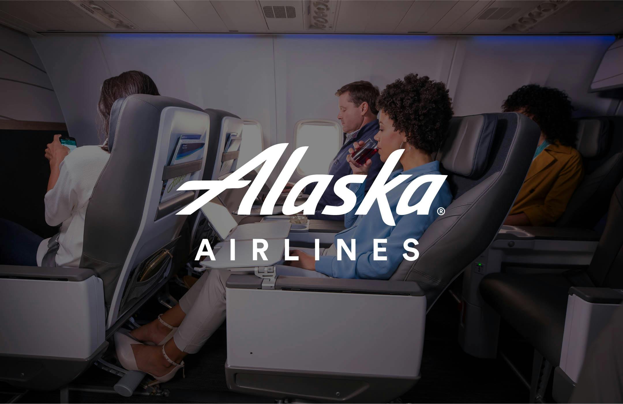 image of Alaska Airlines logo overlaid on a photograph of their first class cabin with people
