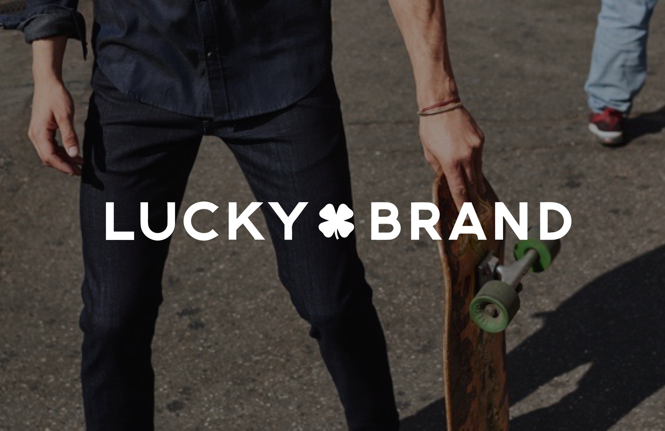 Image displaying Lucky Brand logo and man holding a skateboard. 