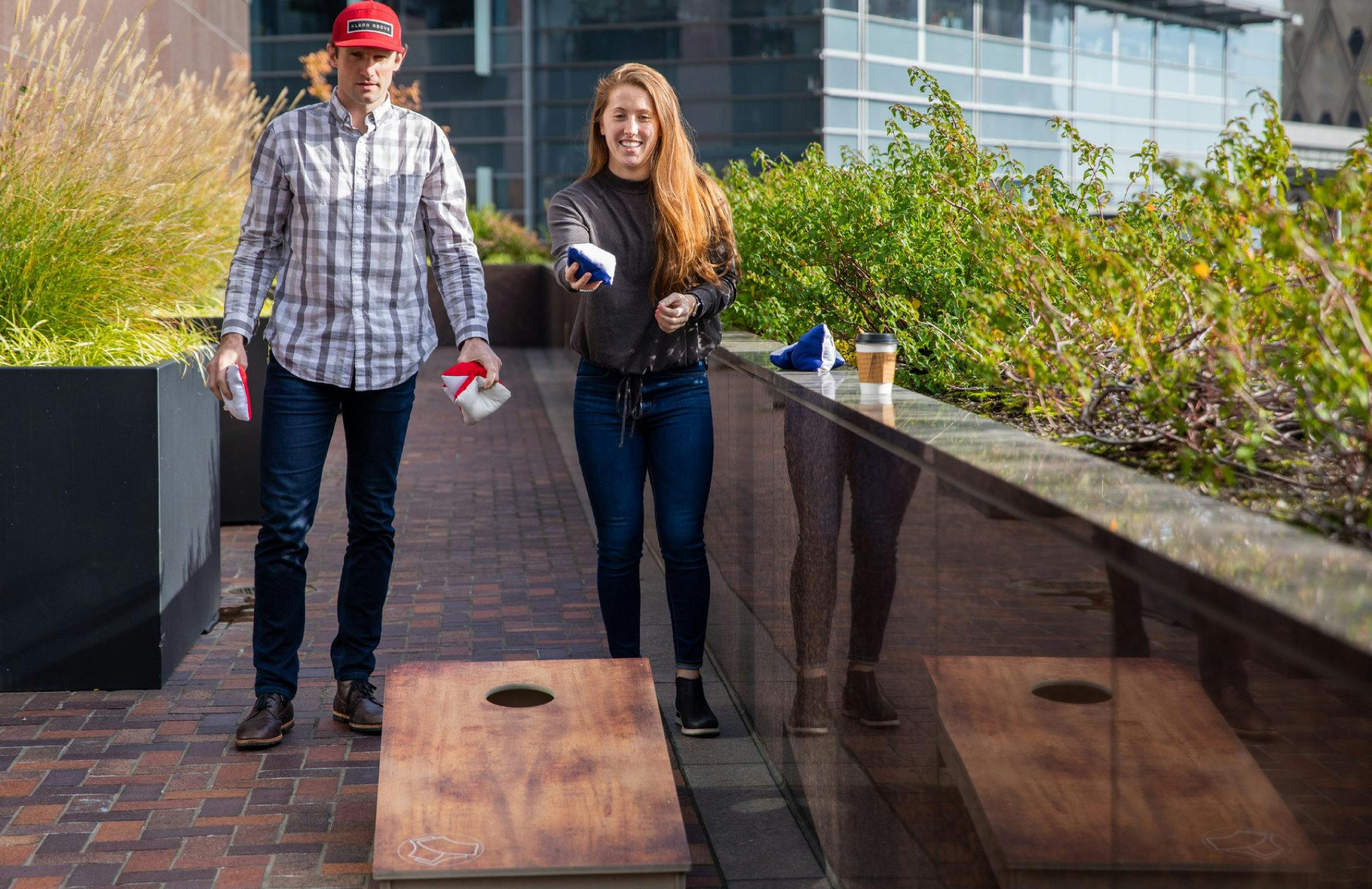 Photograph of two Amperity employees playing corn hole