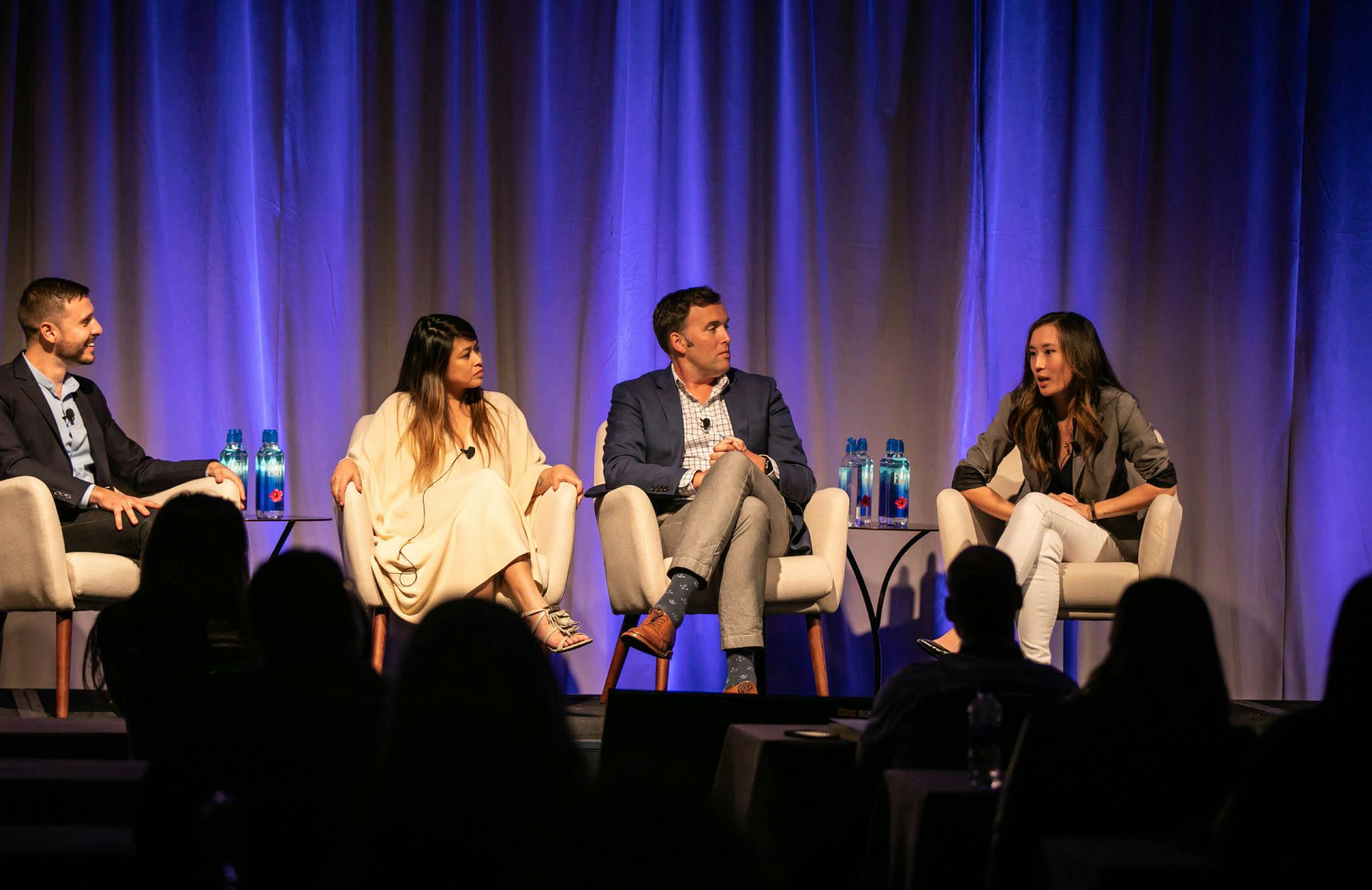 Photograph of four panelists on stage for "Moments that Matter" panel